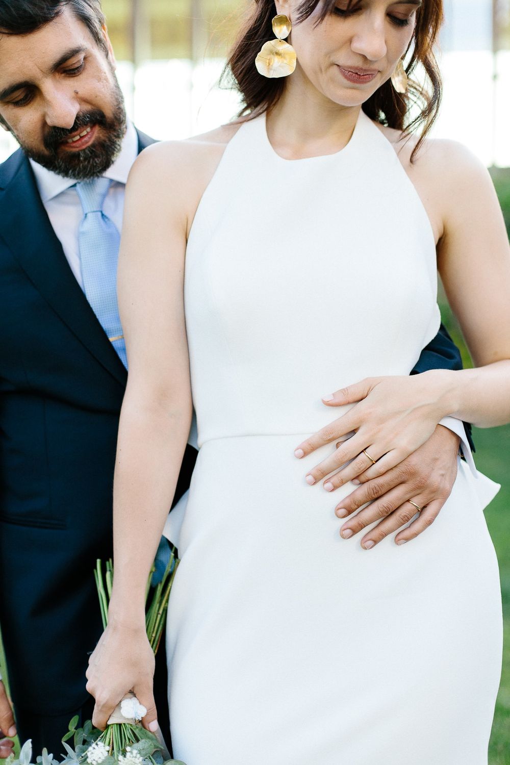 A close-up detail shot of wedding couple embracing in formal attire.