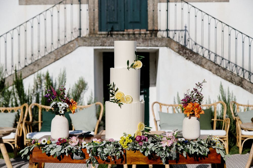 An elegant wedding table setup with floral centerpieces and rustic decor against a white stone staircase.