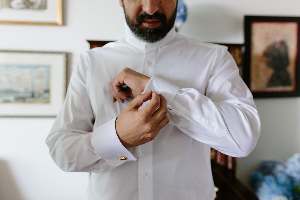 Close-up of formal white shirt being buttoned.