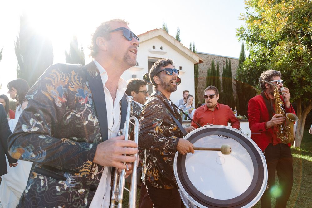 Band members performing with instruments at an outdoor celebration.