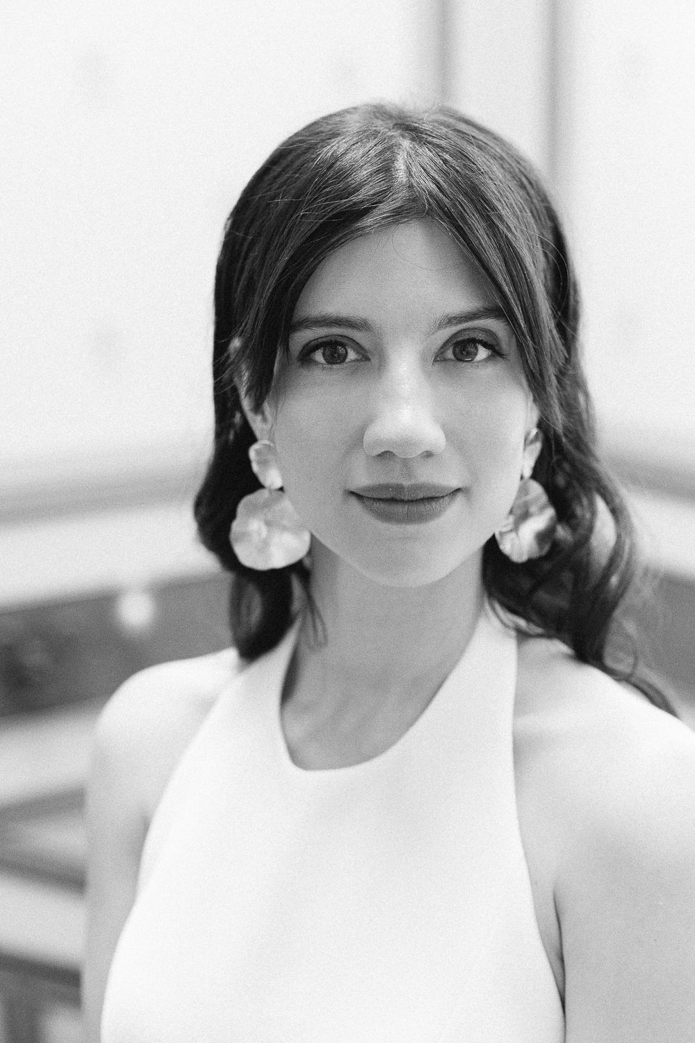 Black and white bridal portrait featuring statement earrings and halter neckline.