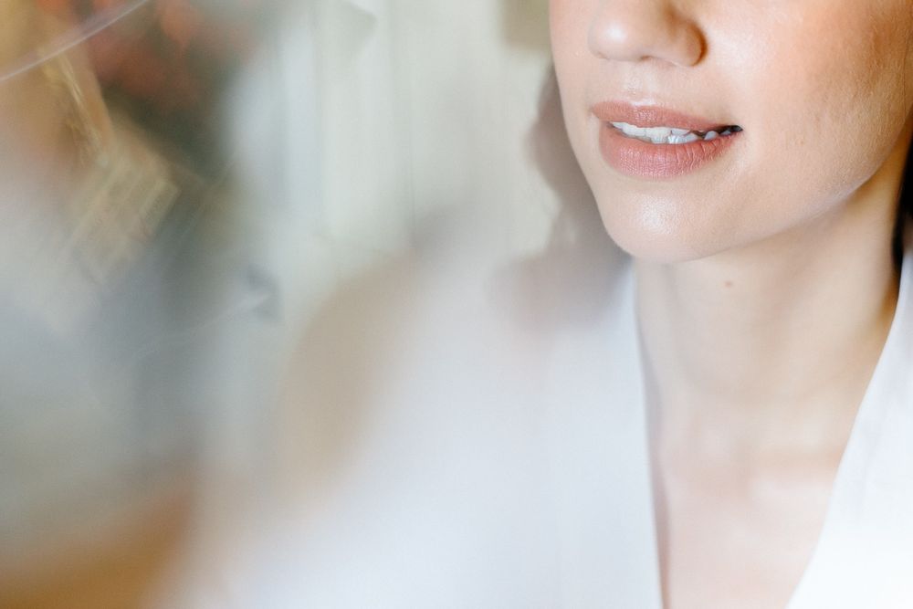 Close-up partial view of someone wearing white against soft focus background.