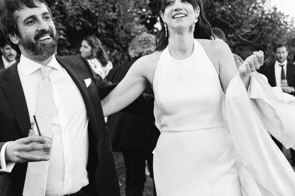 A couple shares a joyful moment dancing at an outdoor celebration.