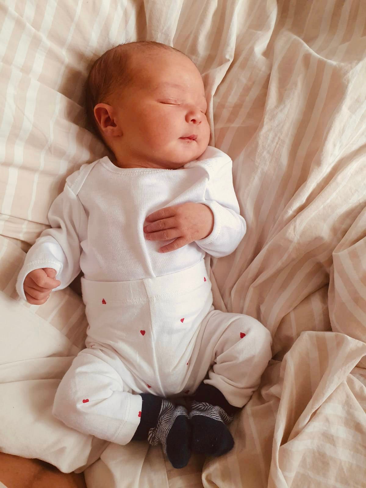 Newborn baby at home on bed in Morden, UK