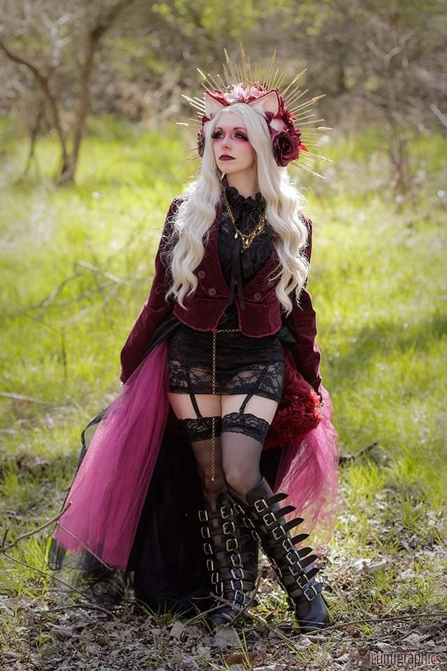 Amanda Adams wearing platinum blonde wig, gold crown with burgundy and pink flowers, and burgundy cat ears.