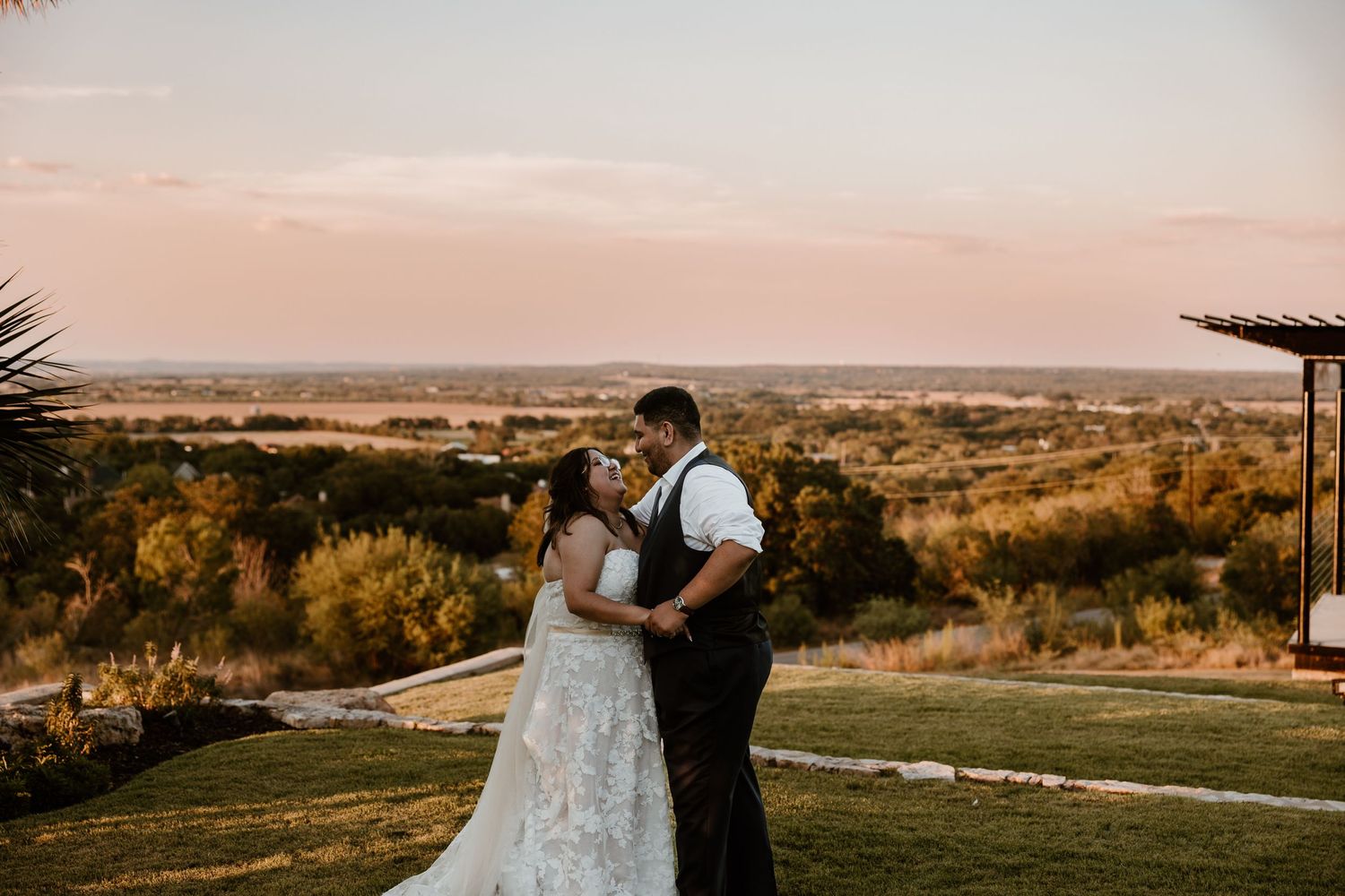 A romantic sunset wedding portrait overlooking a scenic valley landscape.