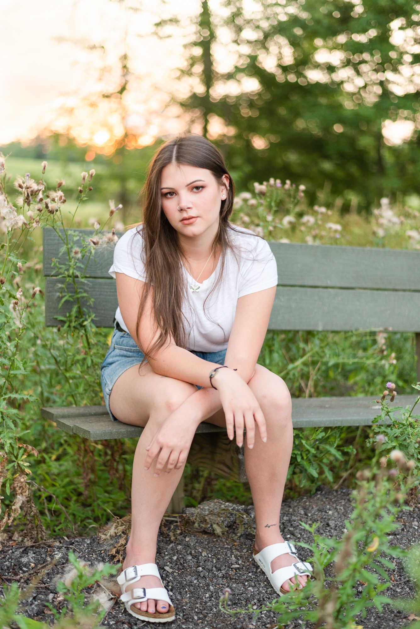 High school senior sitting on bench in golden sunlight at Hartwood Acres in Pittsburgh Pennsylvania
