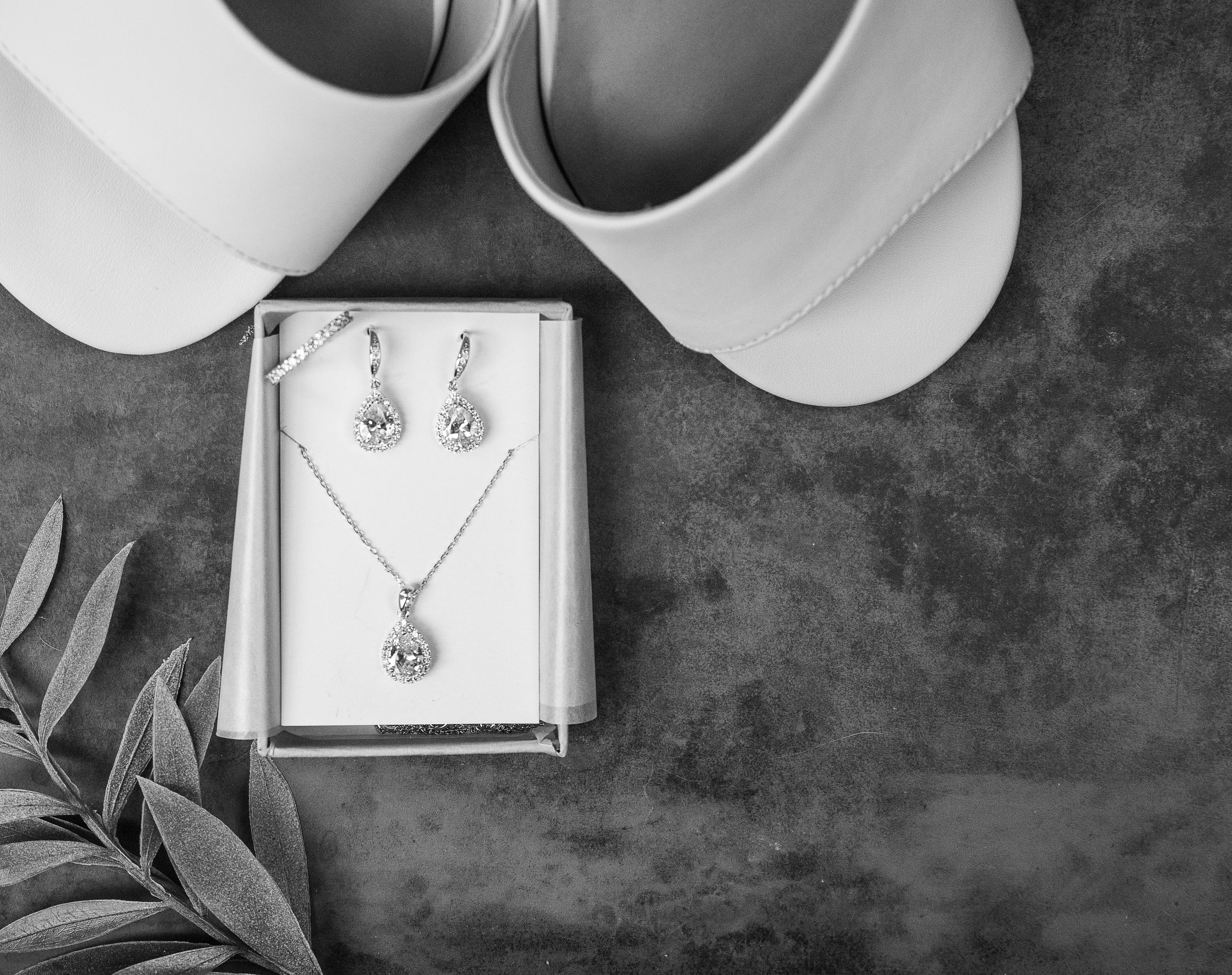 Elegant bridal accessories featuring the bride's shoes, necklace, and earrings