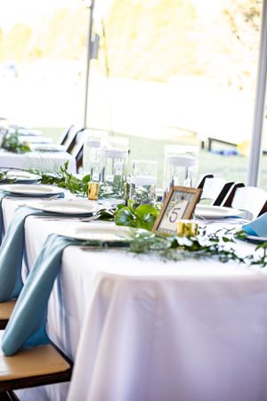 An elegantly arranged table setting, complete with fine china, gleaming silverware, and delicate floral centerpieces, cr