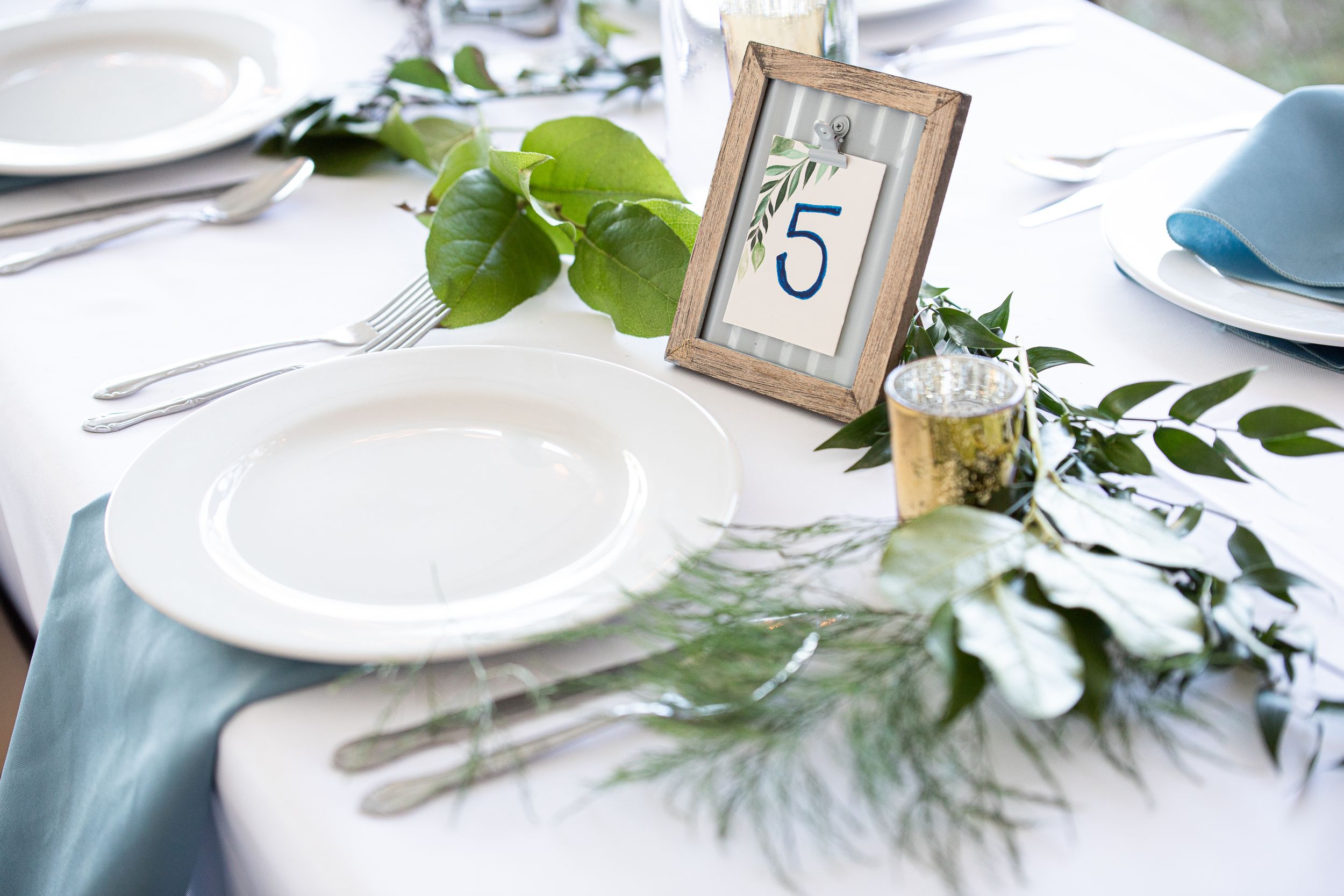 A beautifully set wedding table, adorned with elegant place settings, fine china, and floral centerpieces