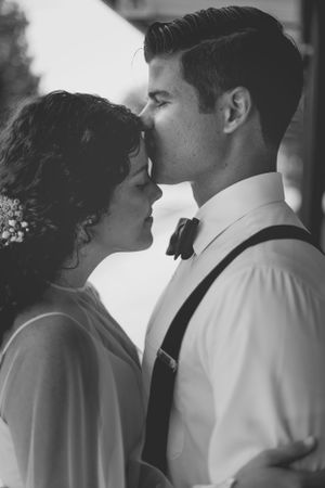 The groom affectionately kissing the bride's forehead, symbolizing his love, protection, and tenderness on their wedding