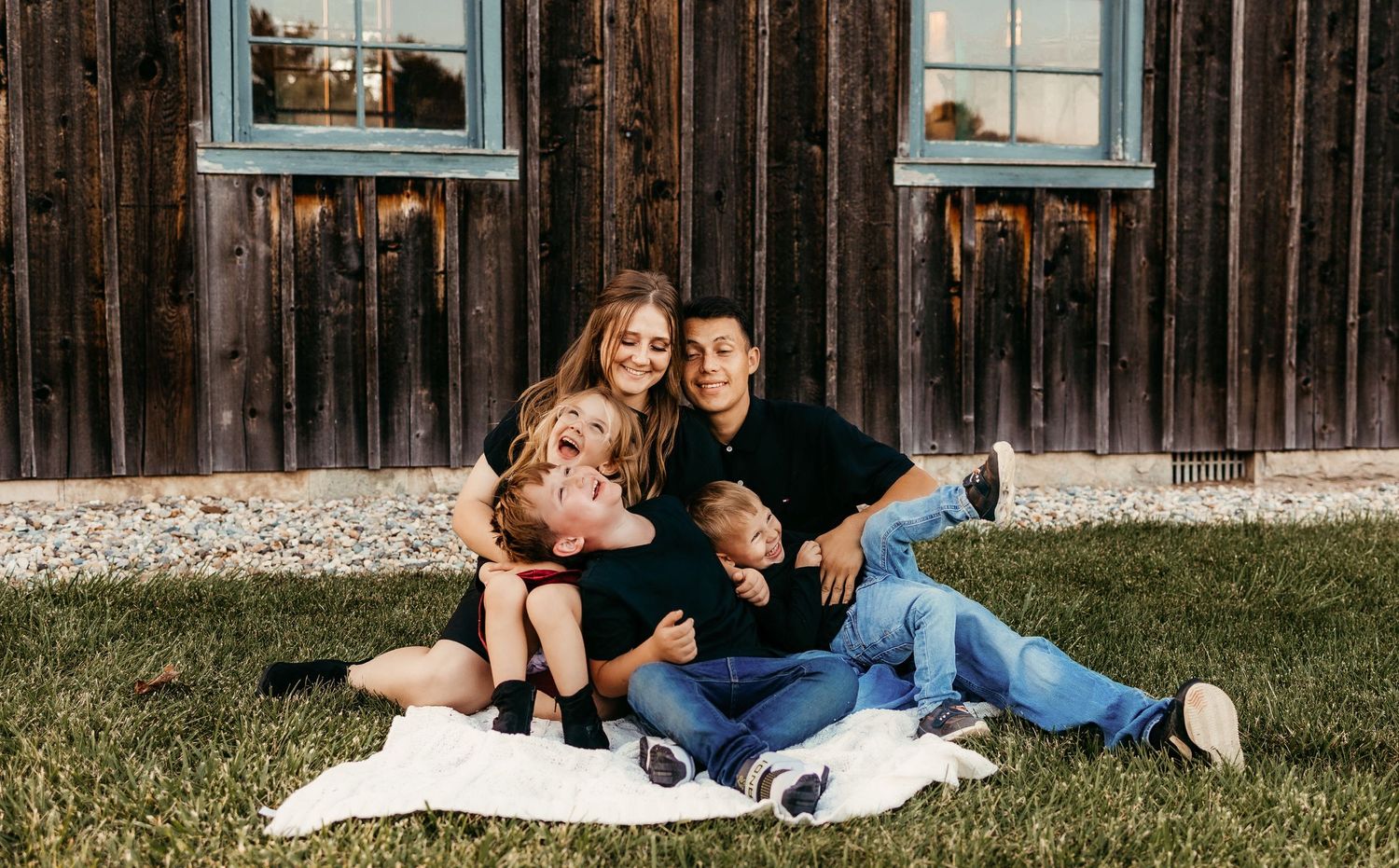 Family of 5 cuddling and laughing while being tickled