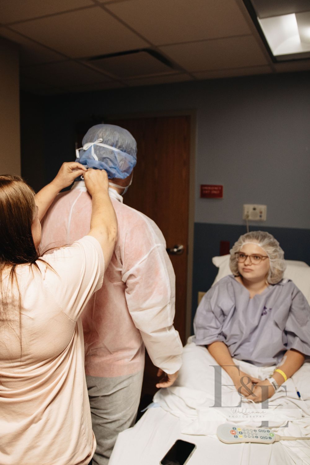 Healthcare workers gathered around a hospital bed during a medical procedure.