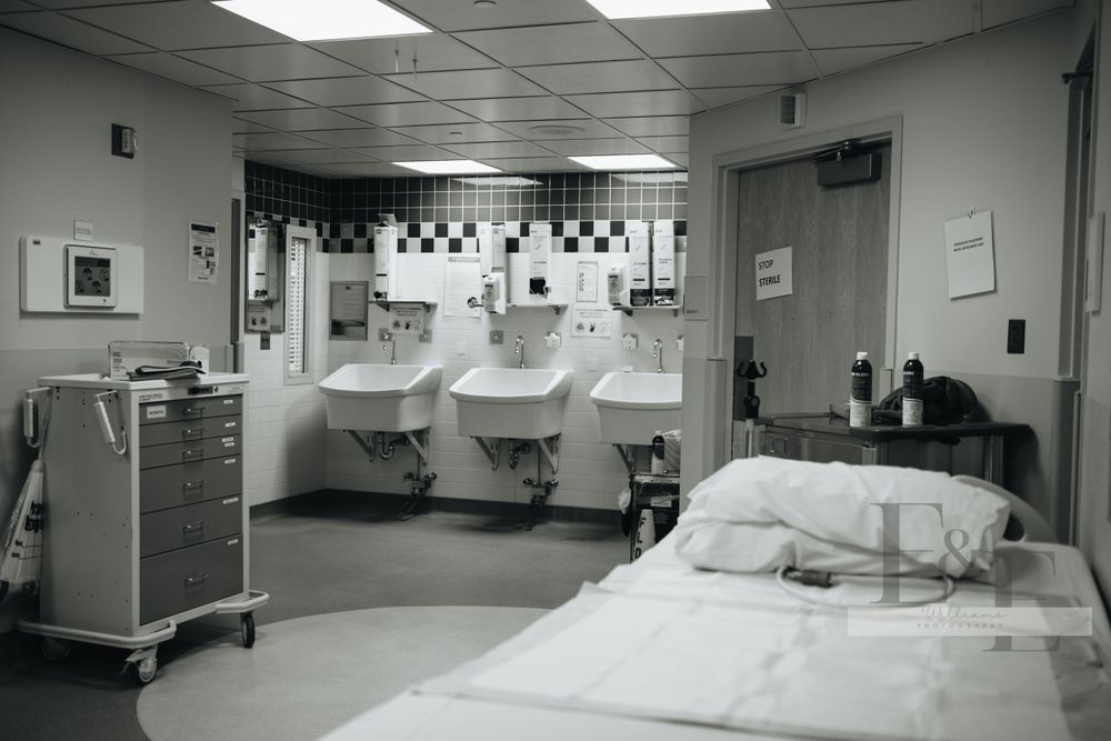 Empty hospital corridor with medical equipment and beds visible.