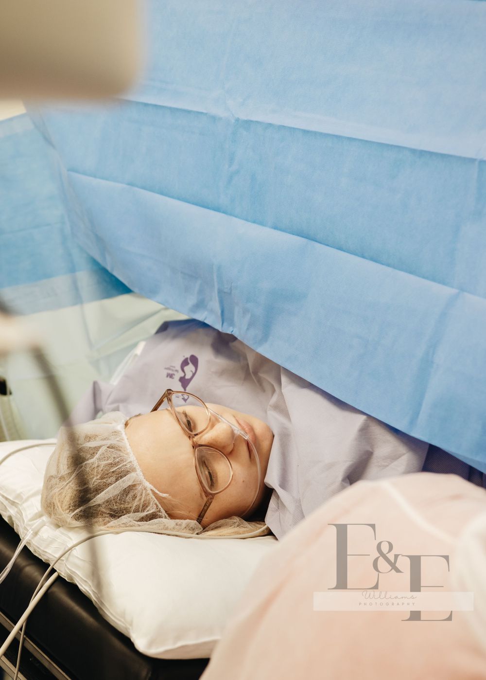 Patient resting under light blue surgical drapes during a medical procedure.