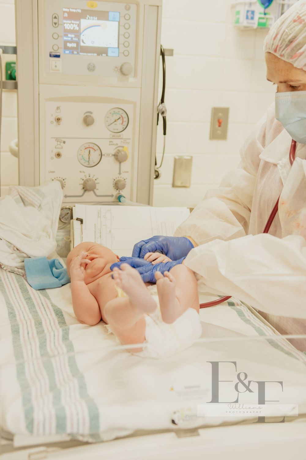 Hospital room setting with medical equipment and striped blankets visible.
