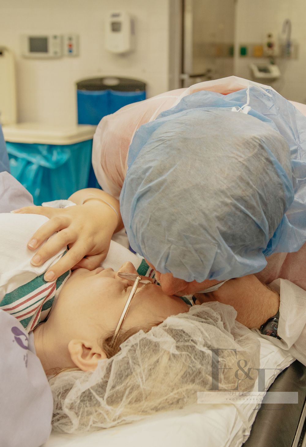 Medical professional performing surgical procedure with blue surgical drapes.