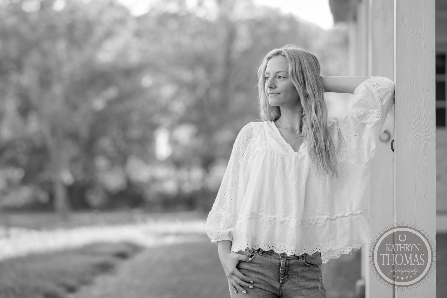 Black and white portrait showing soft natural lighting and romantic styling with flowing white top.