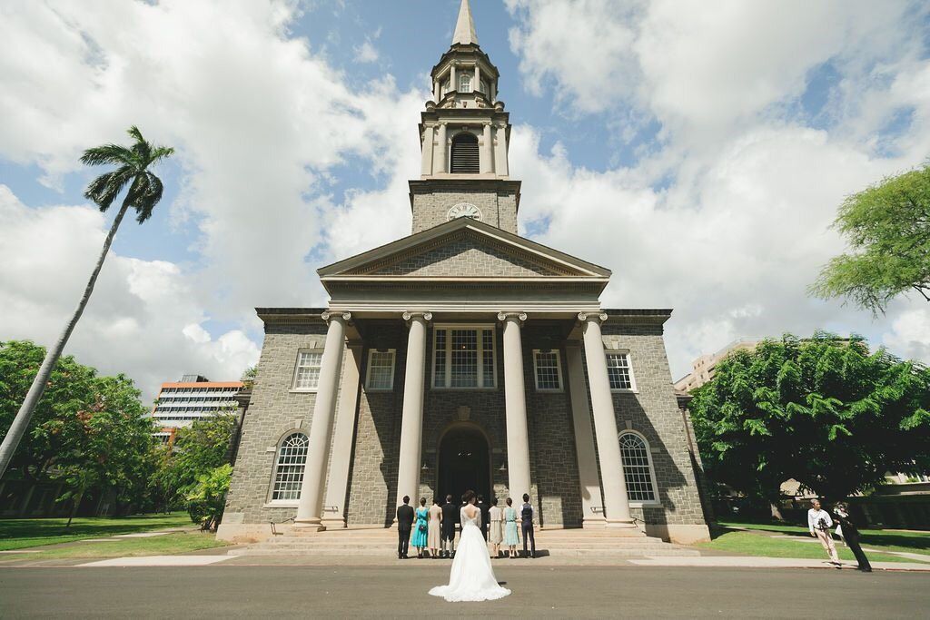 Wedding party poses before a grand colonial stone church with tall steeple and classical columns in Hawaii.
セントラルユニオン大聖堂
ハワイウェディング
ハワイ挙式