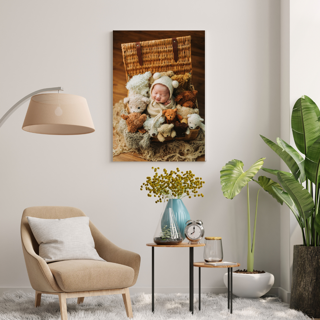 Canvas print of a newborn in a white bear hat sleeping among flowers in a wicker basket, hung in a cozy living room.
