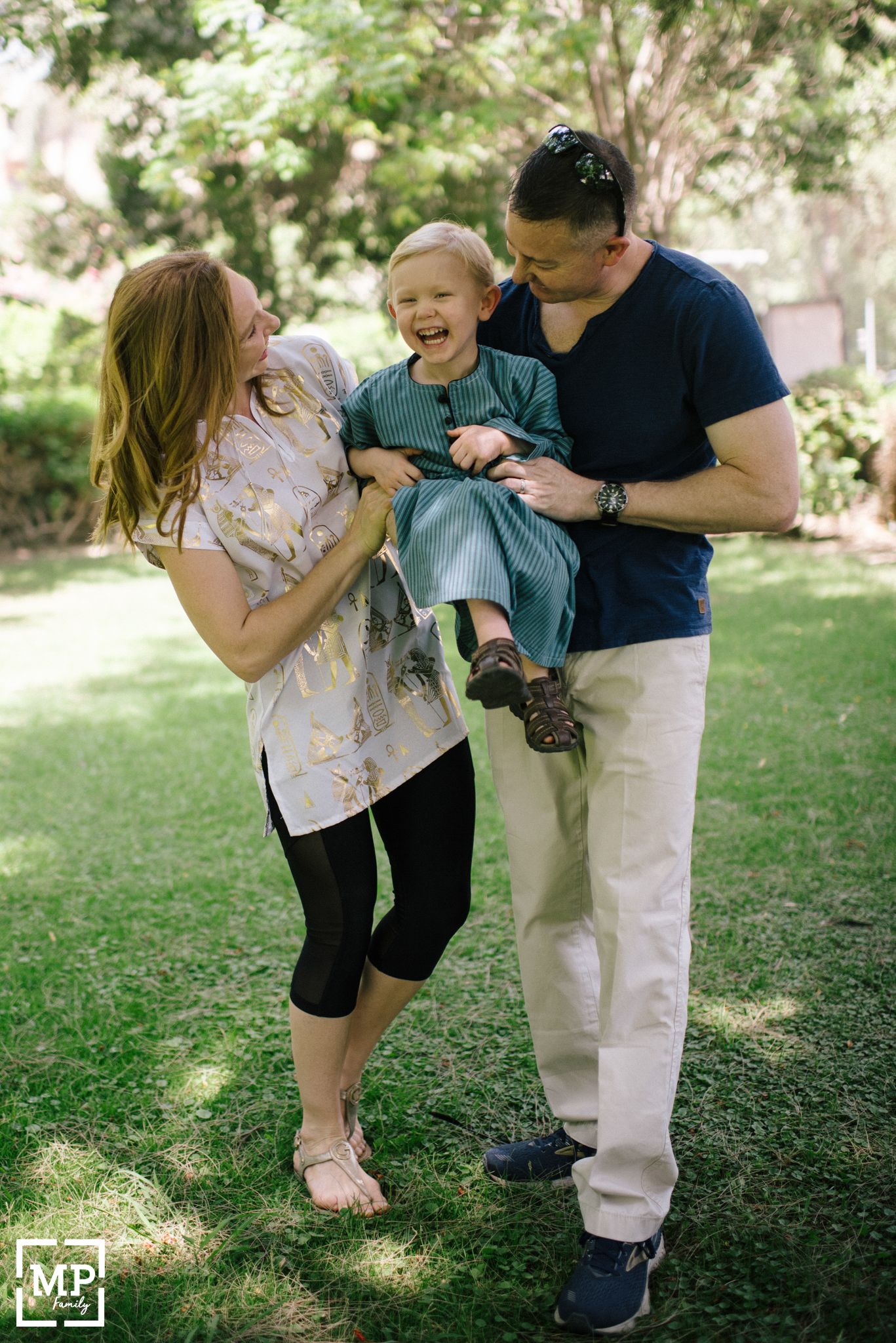 Family shares joyful moment together while playing in sunny garden.