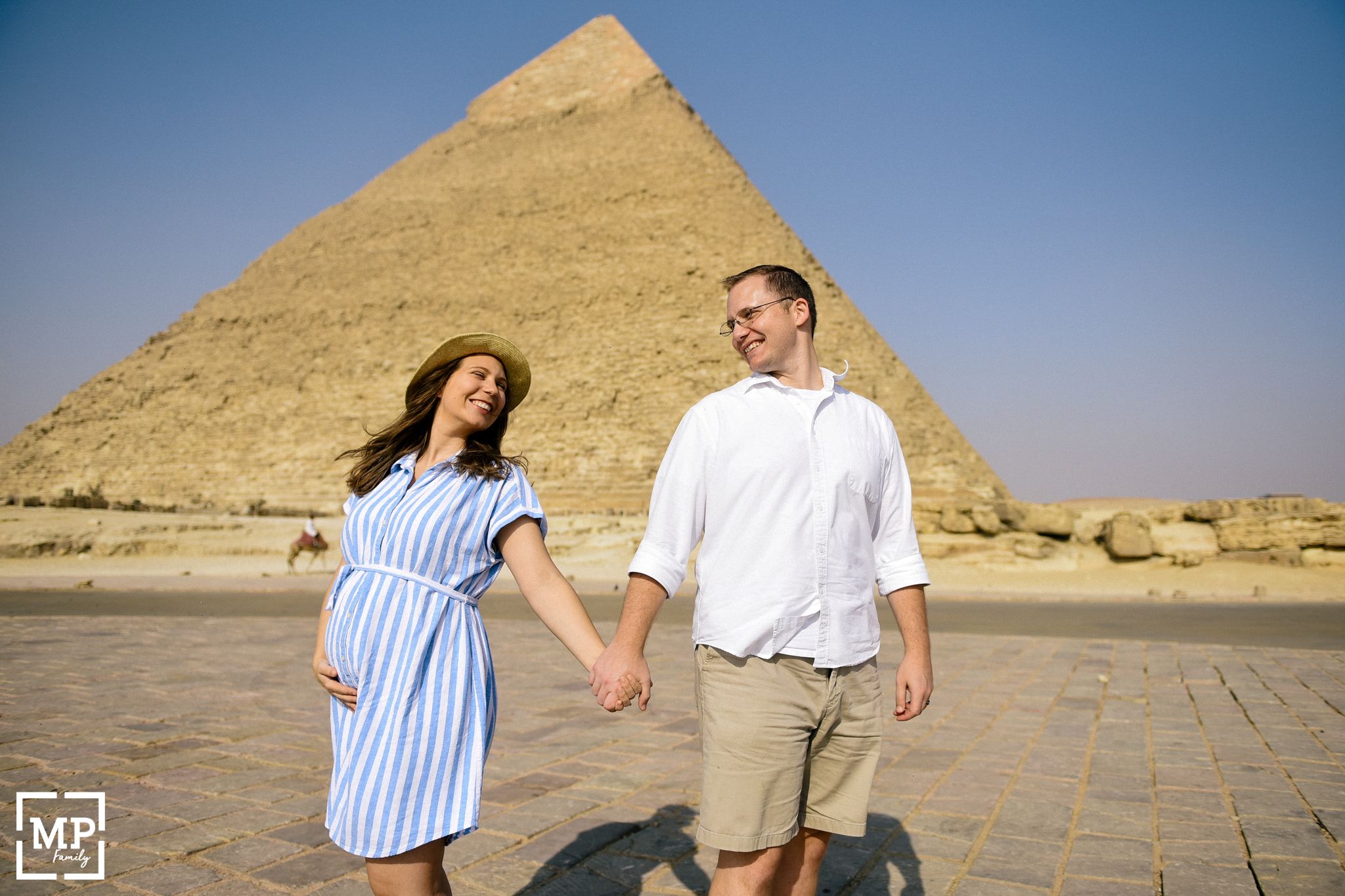 Couple holding hands in front of the Great Pyramid of Giza in Egypt.