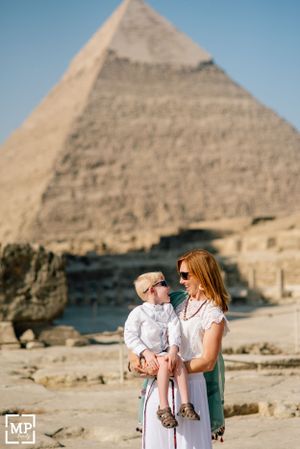 A family poses together in front of the ancient pyramids in Egypt.