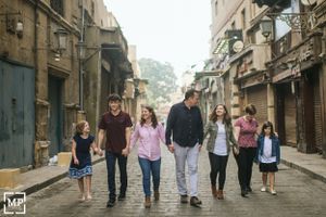 Group walking together down a narrow urban street with historic buildings.
