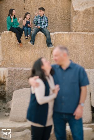 Candid family moment captured on ancient stone steps with multiple people in casual attire.