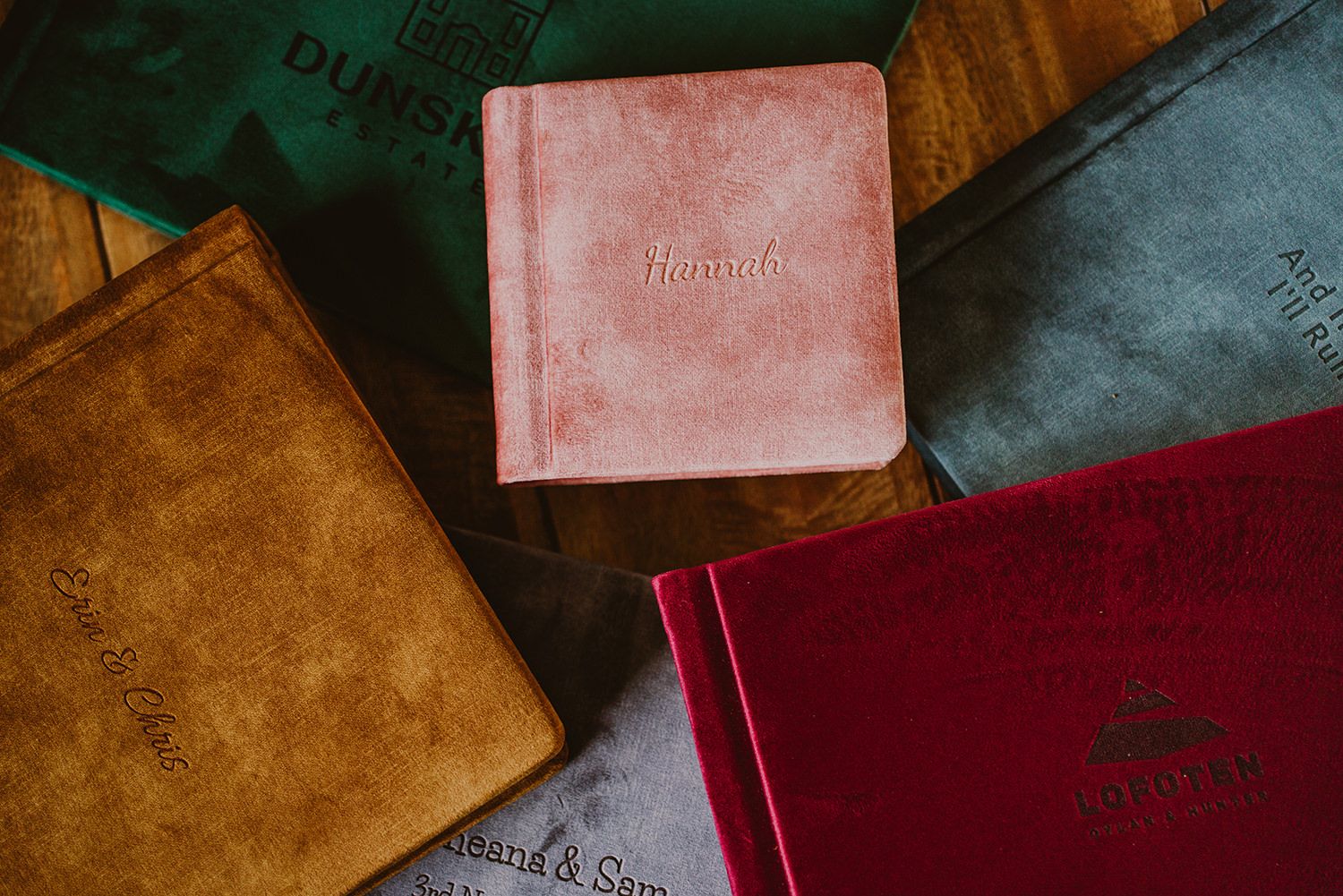 Assortment of leather-bound photo albums in various colors displayed together.