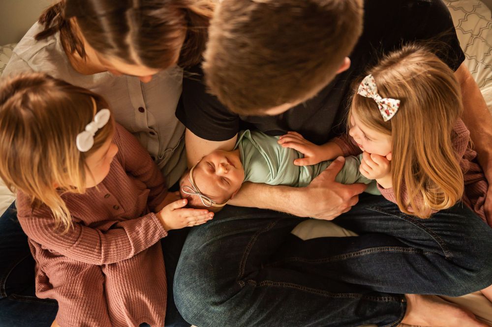 A warm overhead view of a family huddled close together sharing an intimate moment.