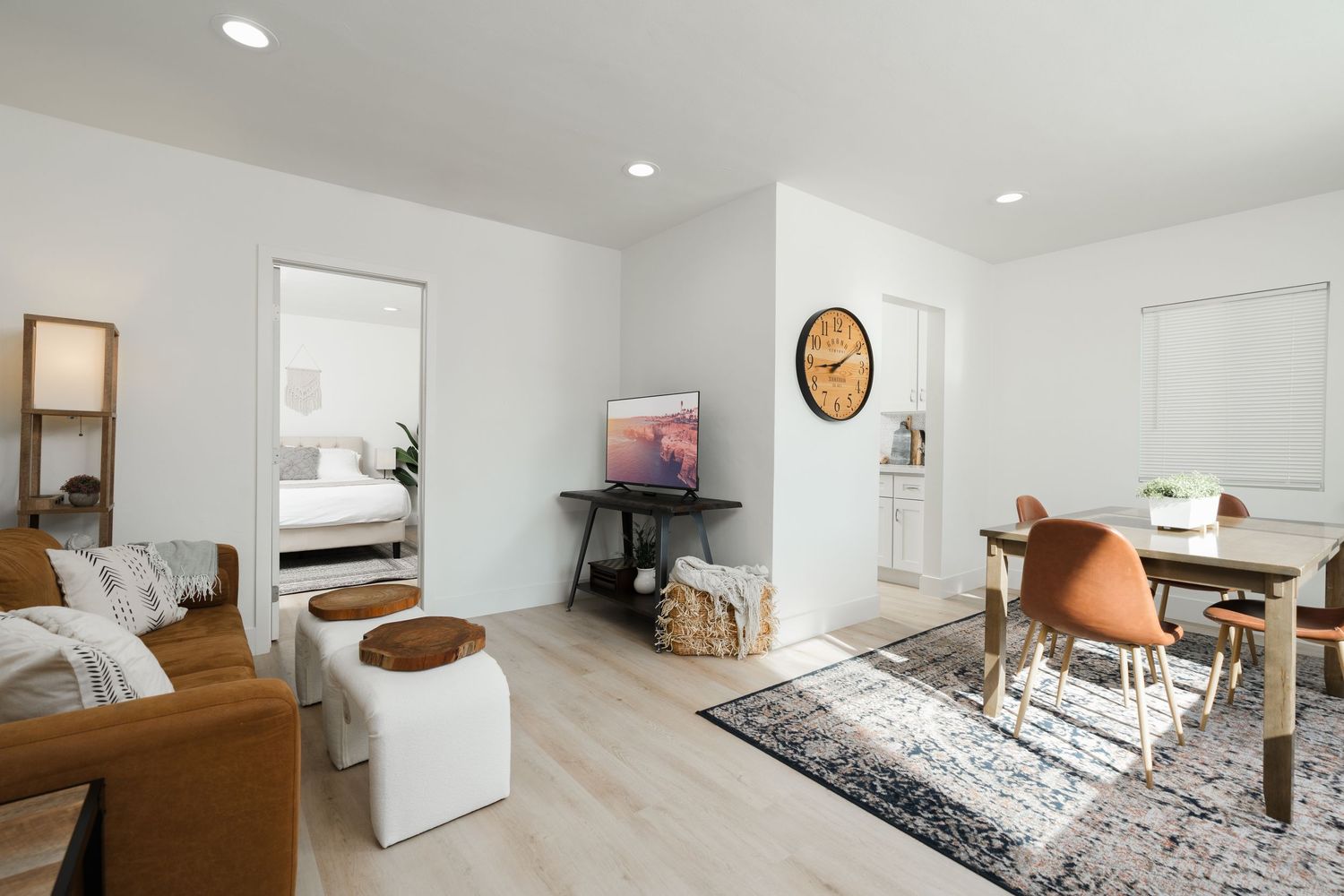 Contemporary living room with wooden floors, modern furniture, and minimalist decor in neutral tones.