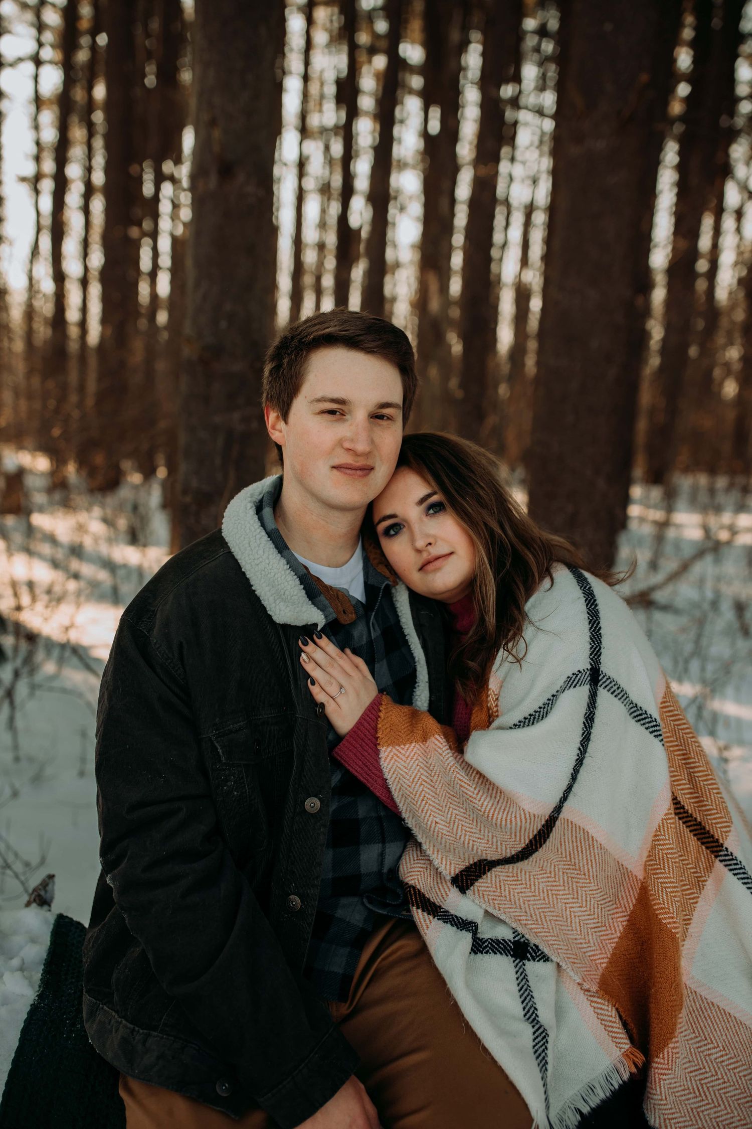couple-sitting-on-log-in-snow