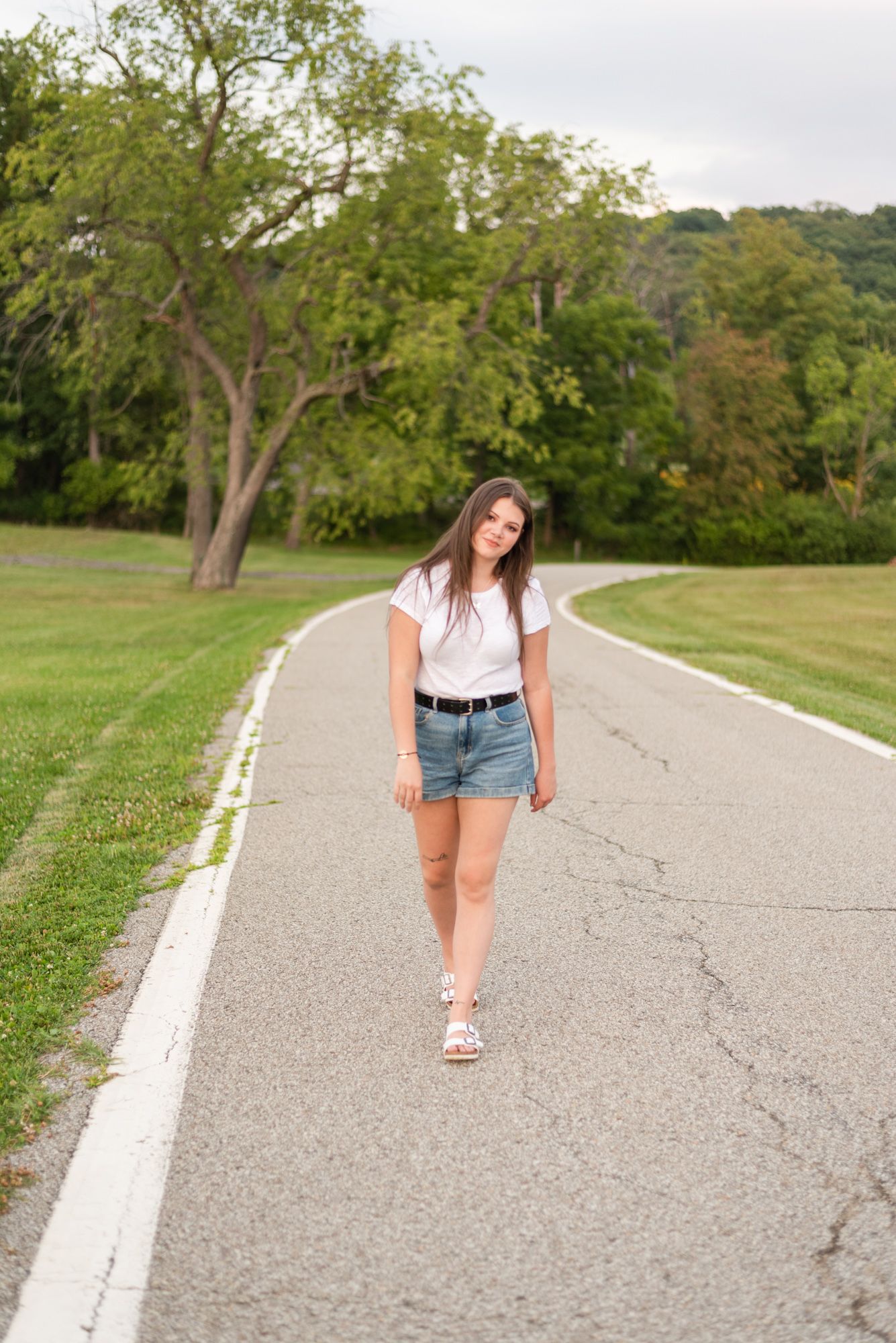 High school senior walking through park in golden sunlight at Hartwood Acres in Pittsburgh Pennsylvania