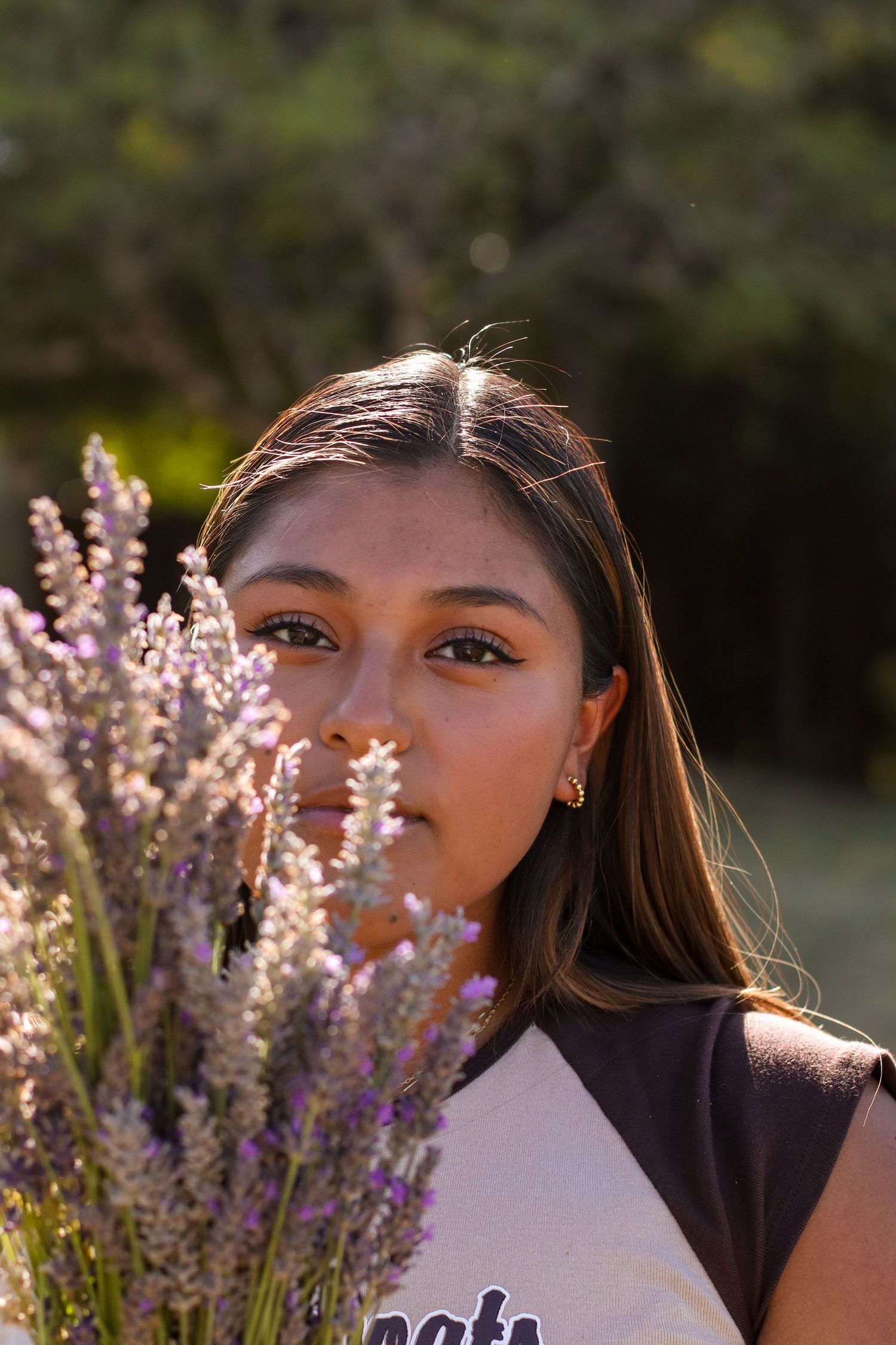Portrait of person posing with lavender bouquet in golden afternoon light.