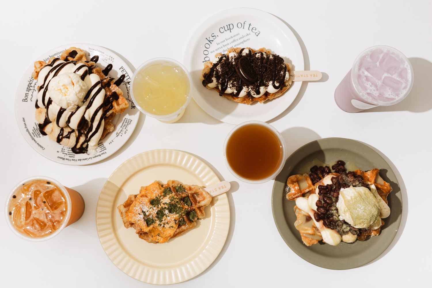 Overhead view of various desserts and drinks arranged on plates with chocolate drizzle.