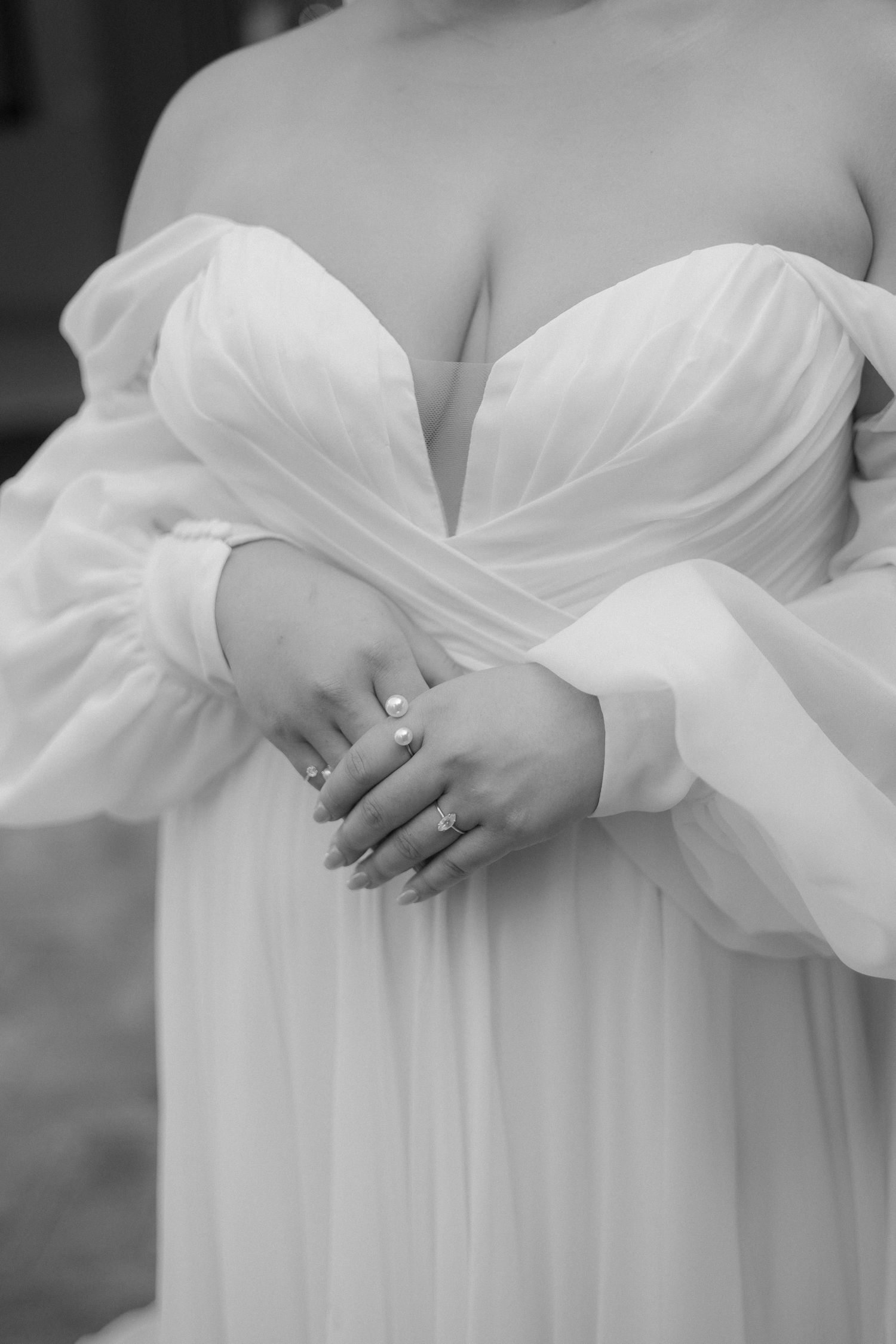 Close-up detail of a white wedding dress bodice showing pleated fabric and delicate design.