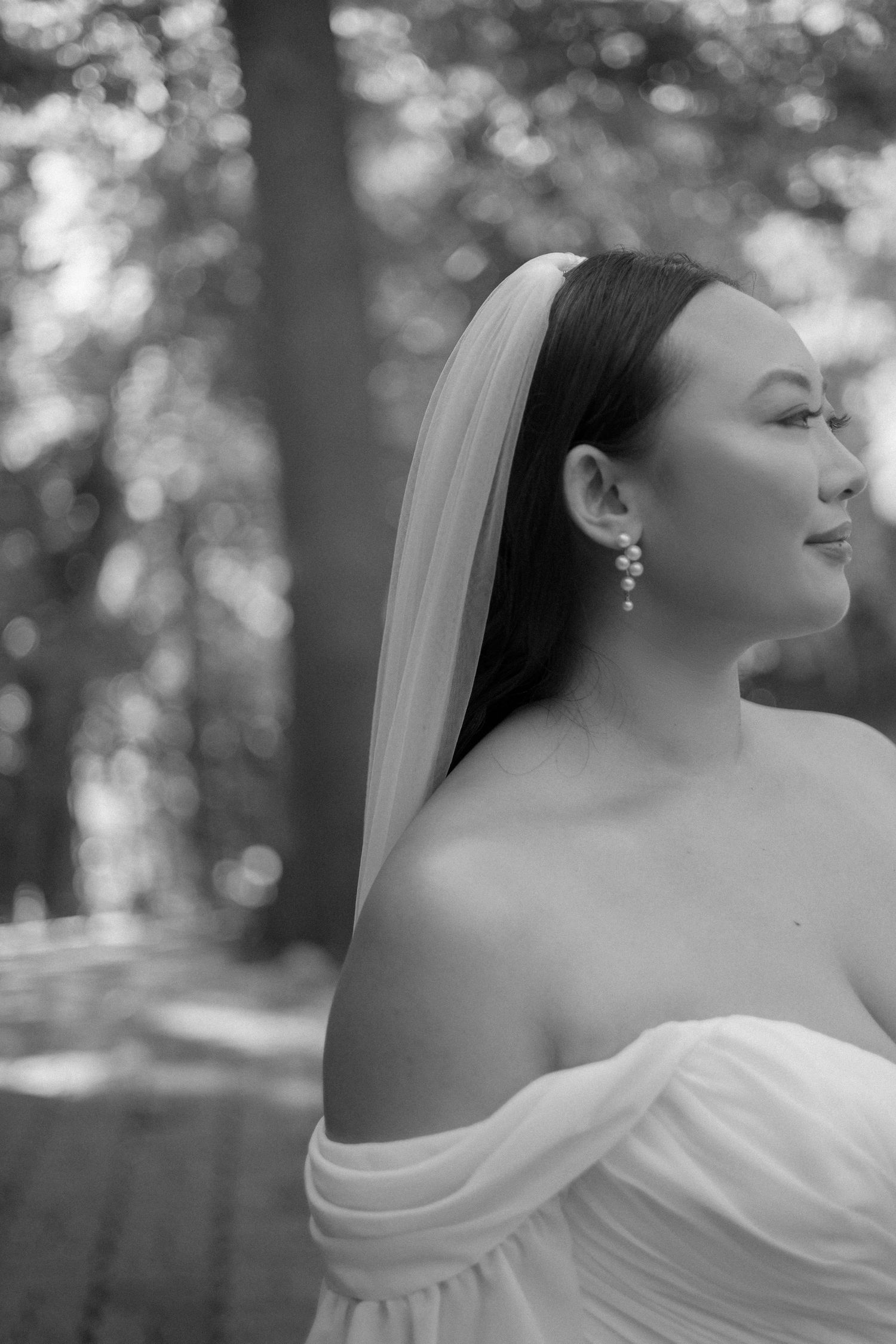Classic black and white profile portrait of a bride wearing elegant drop earrings.