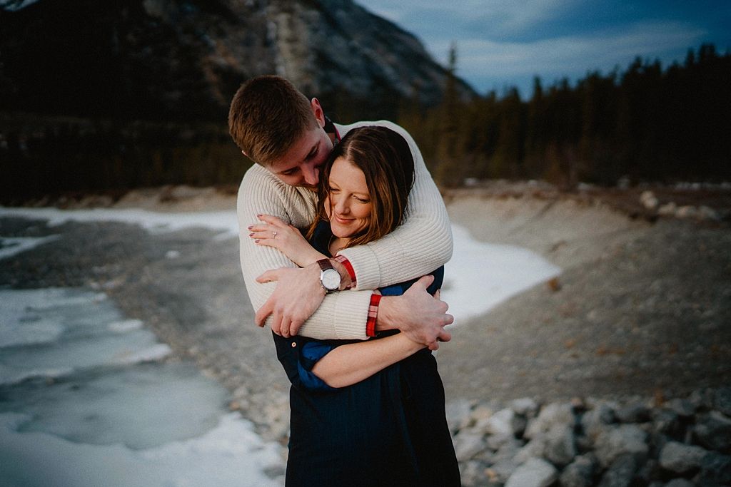 Joyful moment shared between couple in winter mountain setting with natural light.
