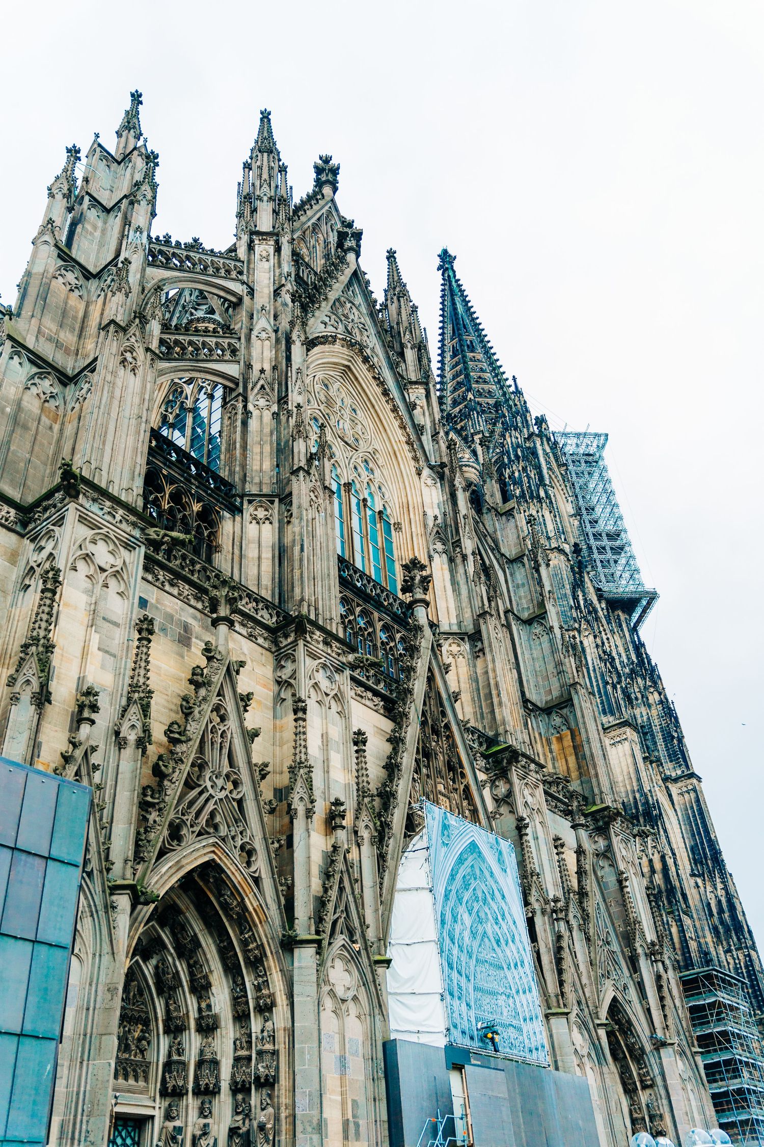 Detailed view of Gothic architecture and flying buttresses on the Cologne Cathedral facade.