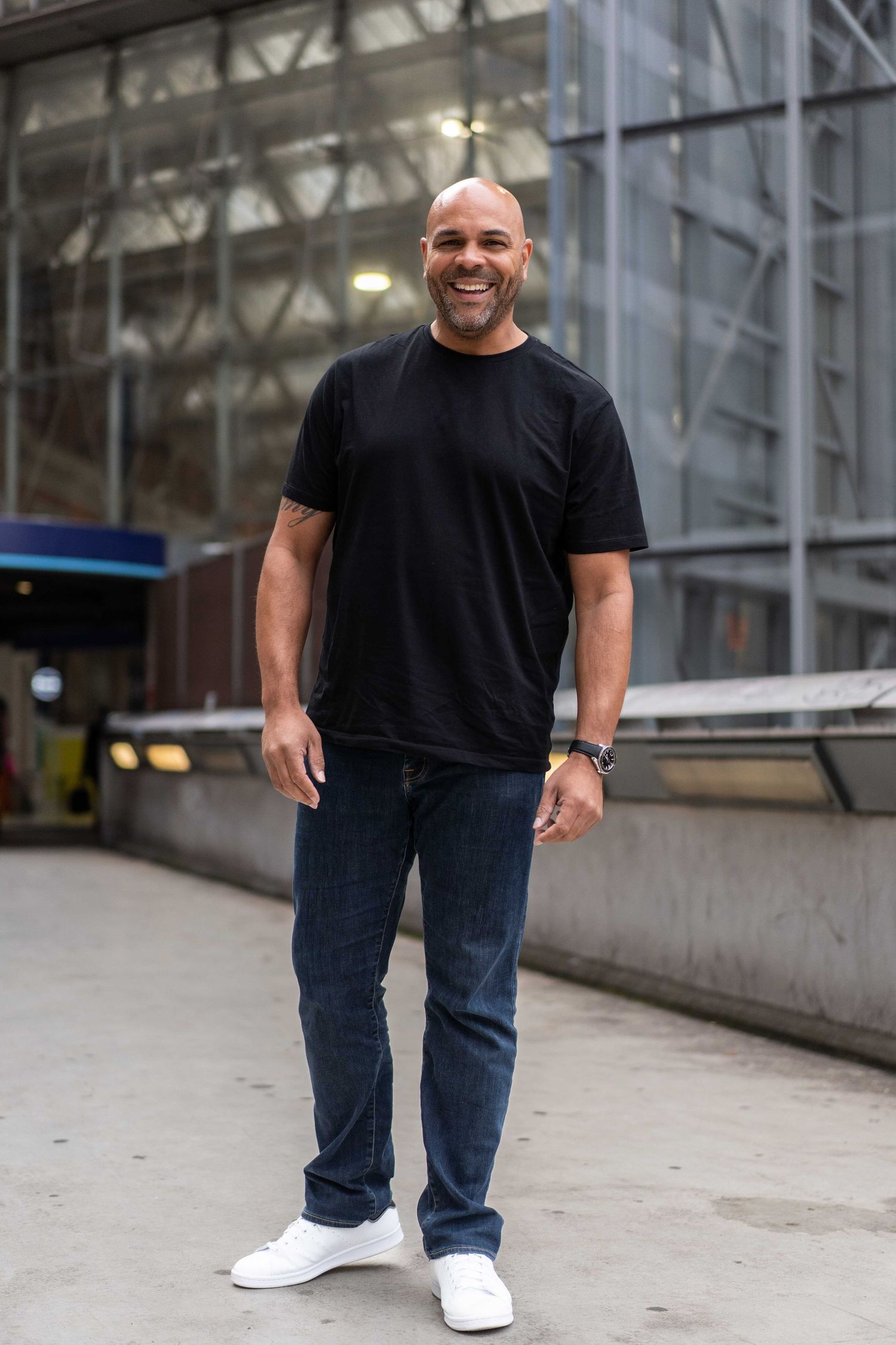 Image of Steve Currie, photographer taken in London outside Waterloo station. Wearing black t short, blue jeans.