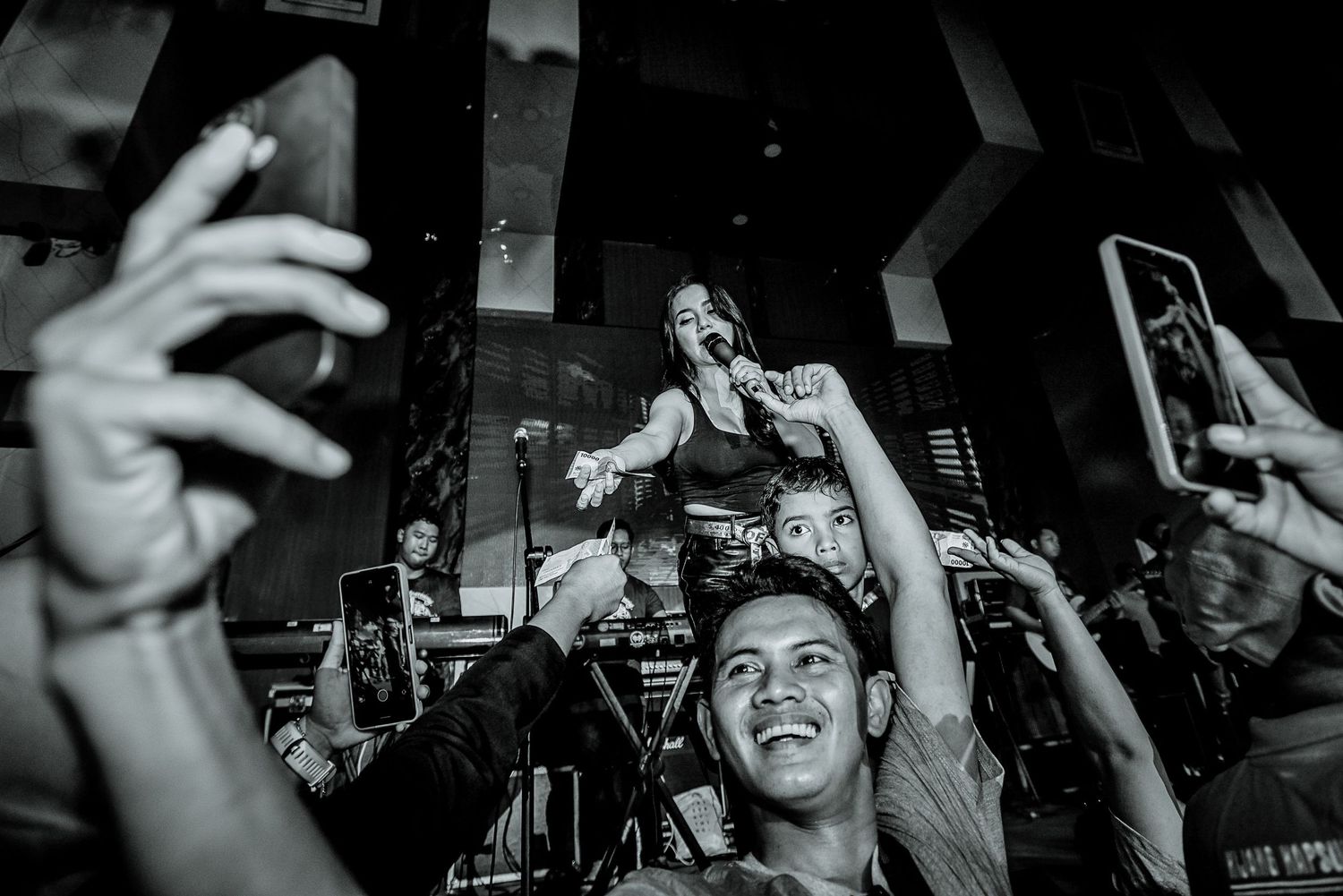 Black and white concert photo showing performer above an excited crowd.