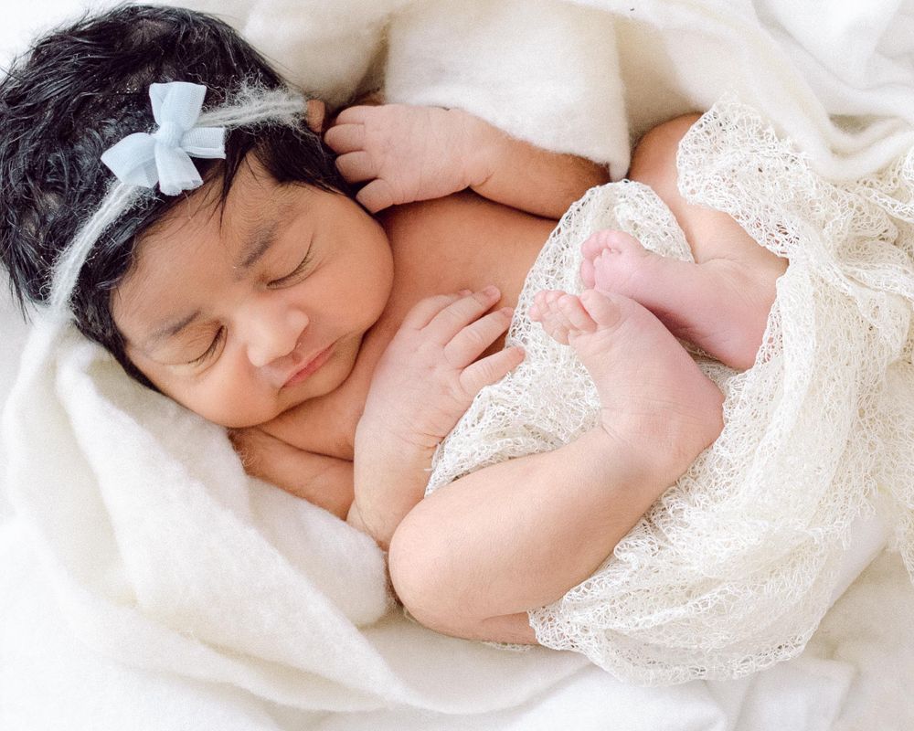 newborn in London in a beautiful off-white setting with a beautiful hair tie