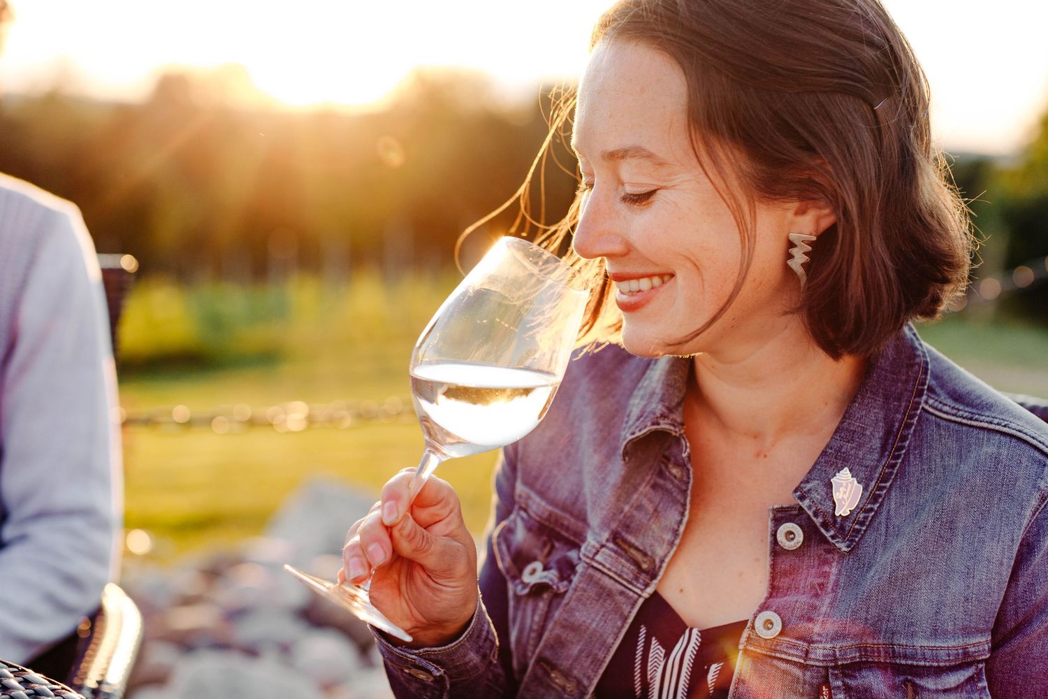 Woman smelling wine in glass at sunset at Rove Estate Winery by Traverse City Marketing & Branding Photographer Grace