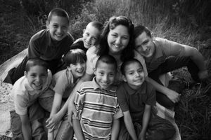 Joyful group huddles together outdoors for a candid black and white photo.
