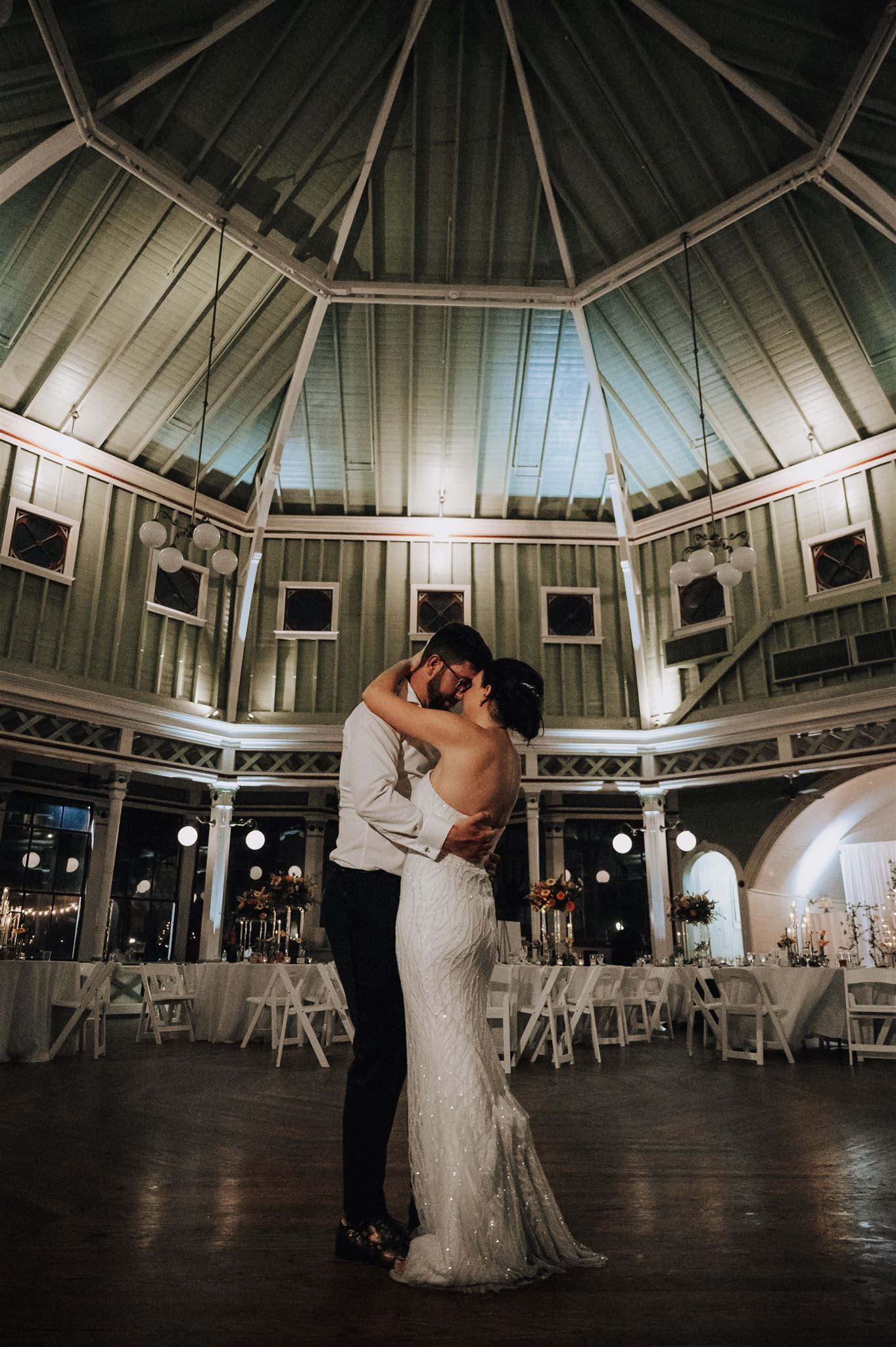 A romantic first dance in an elegant octagonal ballroom with high ceilings and framed artwork on the walls.