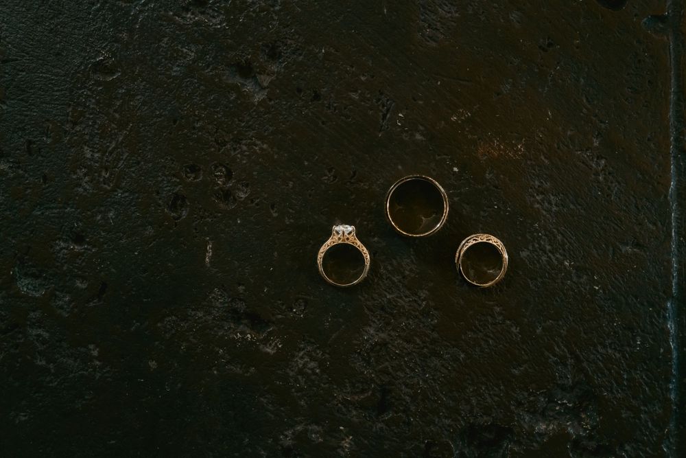 Three elegant engagement rings arranged artistically on a dark textured background.