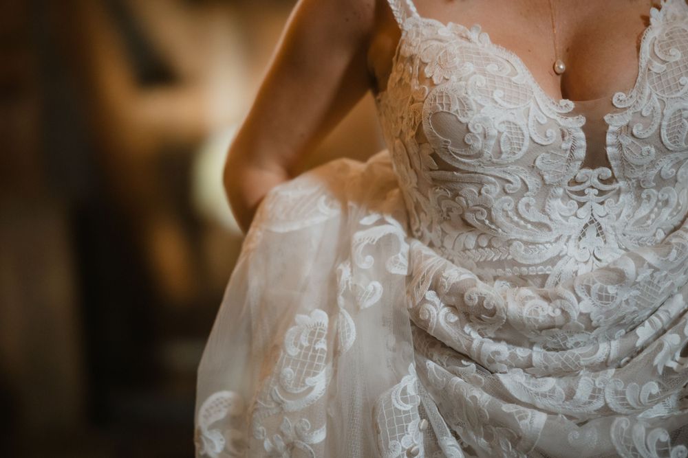 Close-up detail of intricate lace patterns on a white wedding dress bodice.