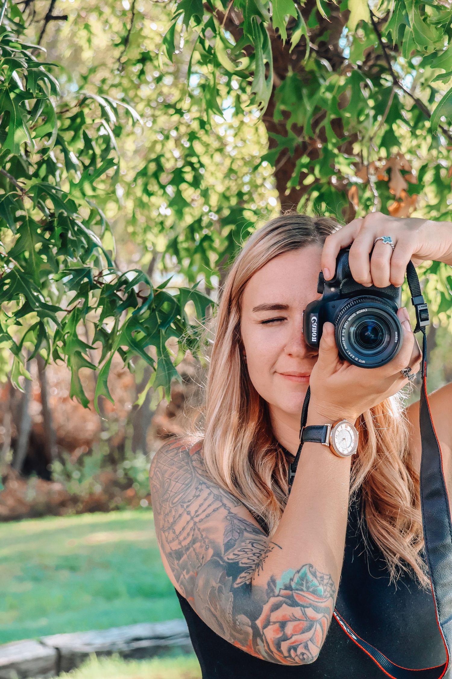Outdoor photography session with camera equipment under green leafy trees.