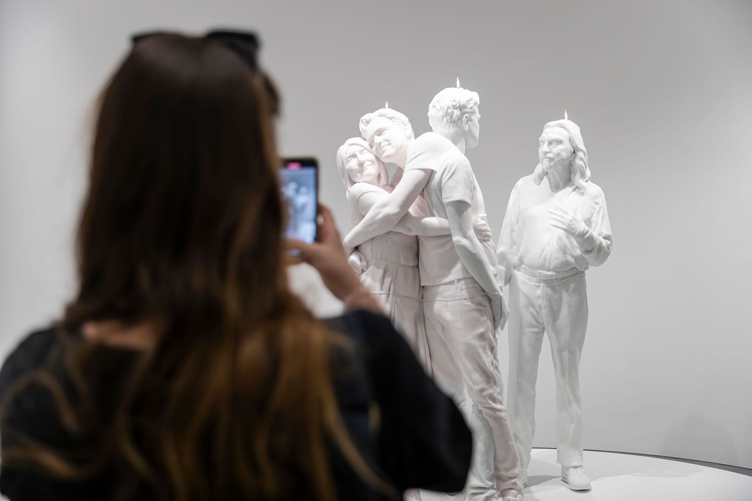 White sculptural art installation being photographed in a gallery space.